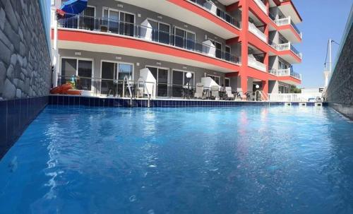 een hotel met een zwembad voor een gebouw bij M & M Red Luxury in Paralia Katerinis