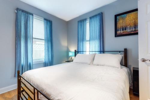 a bedroom with a large bed with blue curtains at Town of Rehoboth Beach 109 Country Club Dr in Rehoboth Beach
