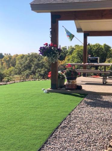 a green lawn with a bench and a flag at Pine River Cabin 2 BR Bayfield in Bayfield