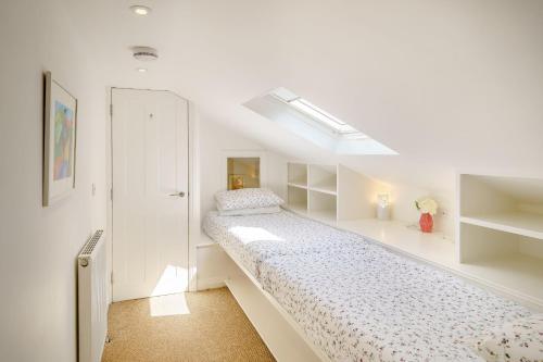 a white bedroom with a bed and a closet at Hawkrigg Cottage in Barbon