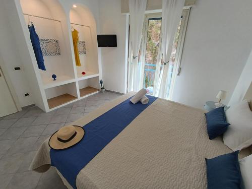 sypialnia z dużym łóżkiem z kapeluszem w obiekcie Maison Clemi w Sorrento