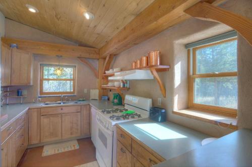 a kitchen with wooden cabinets and a stove top oven at Pine Meadow Cabin 160 Sierra Circle in Vallecito