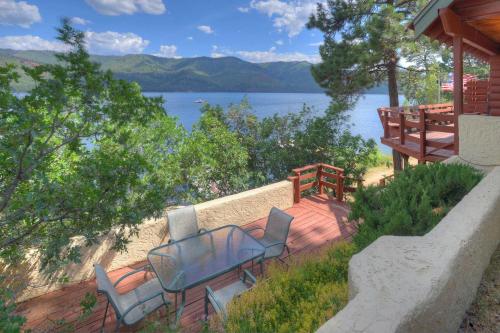 a deck with two chairs and a view of a lake at Waterfront Cabin on Vallecito Lake in Vallecito