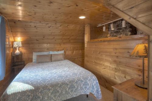 a bedroom with a bed in a log cabin at Waterfront Cabin on Vallecito Lake in Vallecito