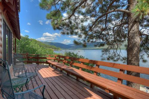 a wooden bench sitting on a deck next to a lake at Waterfront Cabin on Vallecito Lake in Vallecito