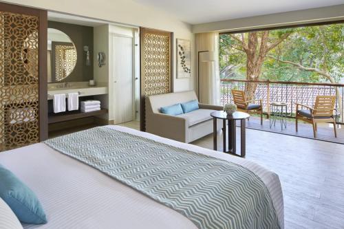 a bedroom with a bed and a view of a patio at Secrets Papagayo All Inclusive - Adults Only in Culebra