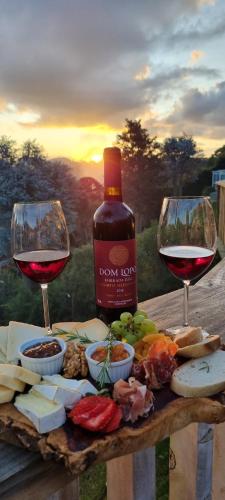 a table with two glasses of wine and cheese at Recanto dos Moinhos - Boutique Hotel in Campos do Jordão