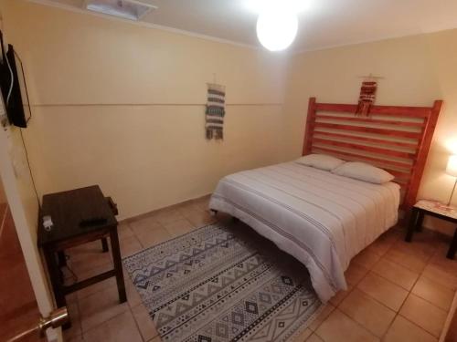 Dormitorio pequeño con cama y mesa en Hostal CacTus, en Coquimbo