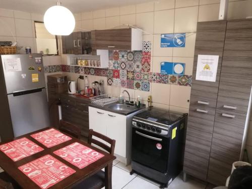 a small kitchen with a stove and a refrigerator at Hostal CacTus in Coquimbo