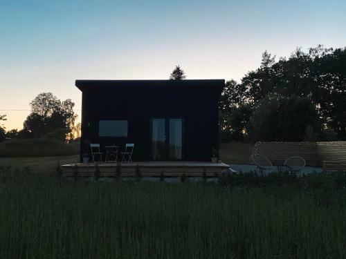 a small cabin with a deck in a field at Field View Cabin in Örebro