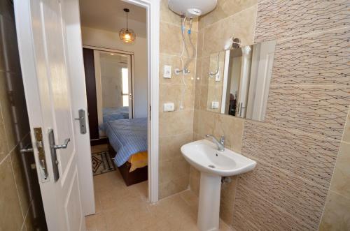 a bathroom with a sink and a mirror at ALFRDOUS LUXURY VACATION HOME NORTH COAST in Sīdī ‘Abd ar Raḩmān