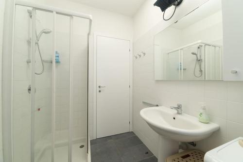 bagno bianco con lavandino e doccia di Un Angolo di Relax a Tavernola Bergamasca