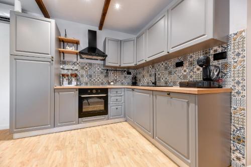 a kitchen with white cabinets and an oven at Vila Nela in Benkovac