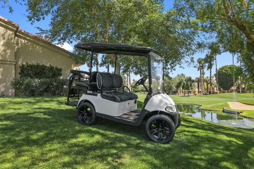 un carro de golf estacionado en el césped en un patio en Palm Valley Full Access to Golf, Tennis, and Pickle Ball- Luxury 3 King Beds 3 Full Baths en Palm Desert