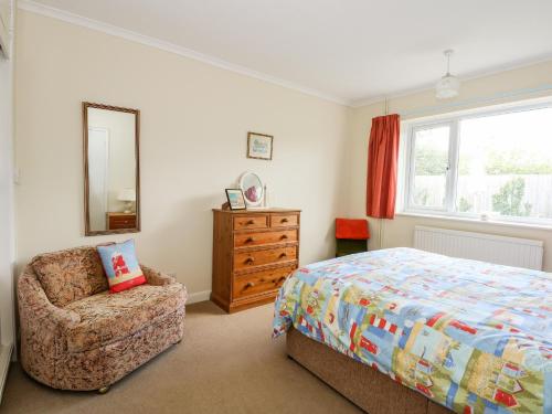 a bedroom with a bed and a chair and a mirror at Newby in Gayton