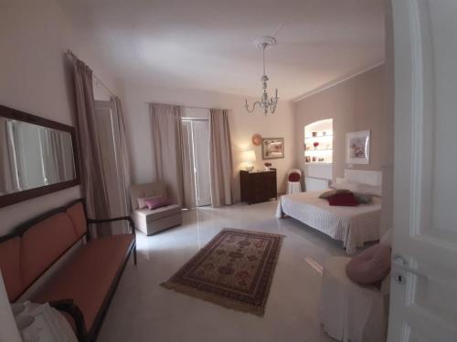 a bedroom with a bed and a couch in it at La Vie En Rose - Casa vacanze in Diamante