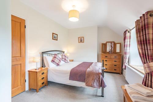 1 dormitorio con 1 cama, vestidor y ventana en Waedog Bach en Llanfor