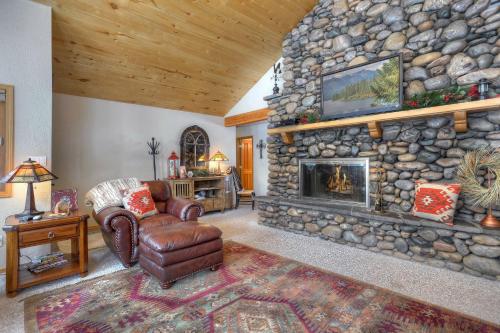 a living room with a stone wall with a fireplace at Seven Pines Cabin in Vallecito Lake Area in Bayfield