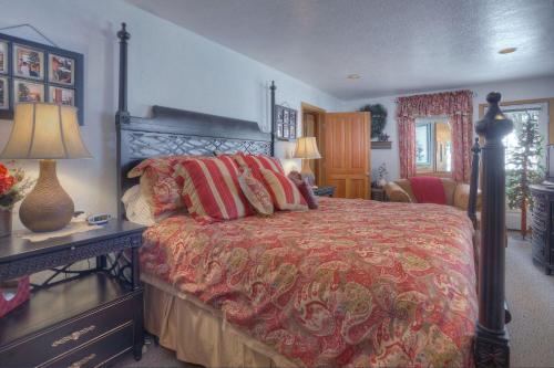 a bedroom with a bed with a red comforter at Seven Pines Cabin in Vallecito Lake Area in Bayfield