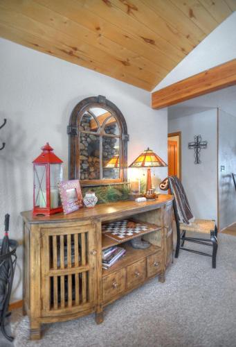 a room with a wooden cabinet with a lamp and a chair at Seven Pines Cabin in Vallecito Lake Area in Bayfield