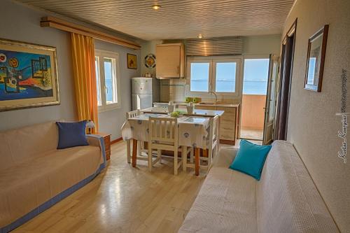 a kitchen and living room with a couch and a table at Aegean Bliss Residences - Karfas in Karfas