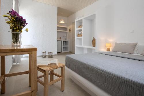 a bedroom with a bed and a table with a vase of flowers at Vavoulas Village in Mikri Vigla