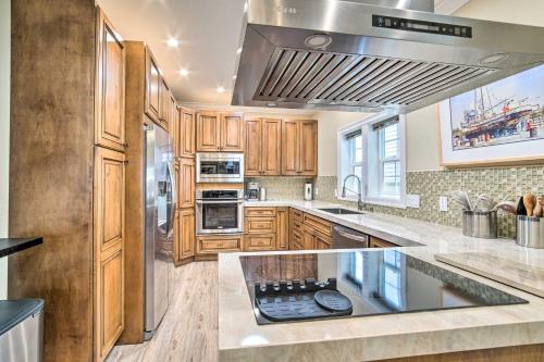 a kitchen with wooden cabinets and a stove top oven at Renovated North Bend Cottage Near Eateries! in North Bend