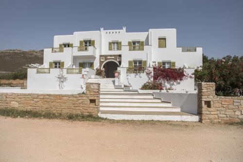 a large white building with stairs in front of it at Vavoulas Village in Mikri Vigla