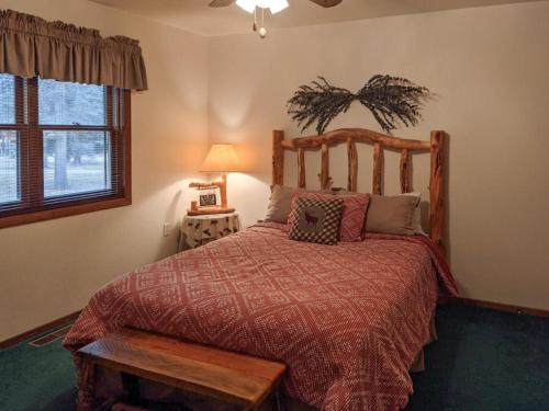a bedroom with a bed with a wooden headboard and a window at Vallecito Family Retreat in Bayfield
