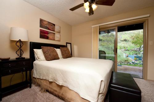 a bedroom with a bed with a ceiling fan and a window at Pine Acres Unit 112 in Durango
