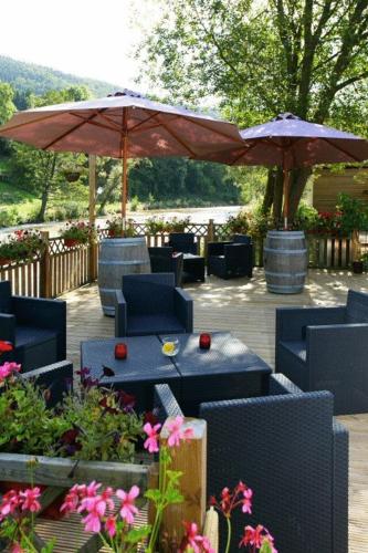 a patio with tables and chairs and umbrellas at Hotel Val De La Cascade in Stavelot