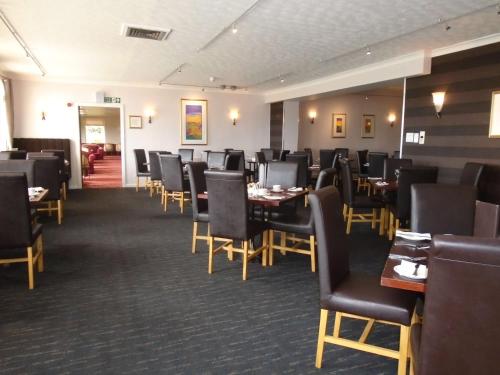 a dining room filled with tables and chairs at Pitbauchlie House Hotel - Sure Hotel Collection by Best Western in Dunfermline