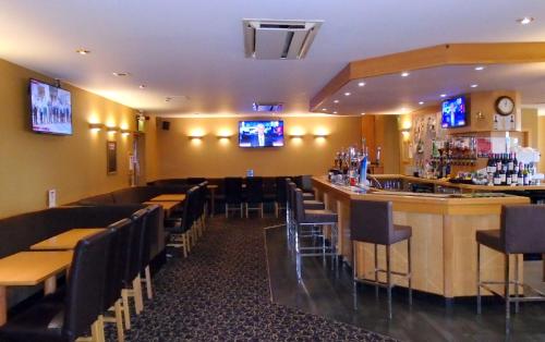 a bar in a restaurant with tables and chairs at Pitbauchlie House Hotel - Sure Hotel Collection by Best Western in Dunfermline