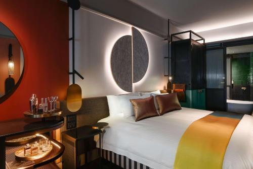 ein Hotelzimmer mit einem Bett und einem Spiegel in der Unterkunft QT Newcastle in Newcastle