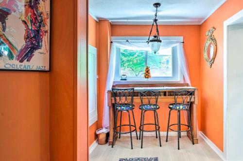 a kitchen with orange walls and two bar stools at Dtwn Elizabethtown Home with Fire Pit and Gas Grill! in Elizabethtown