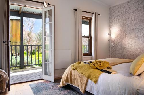 a bedroom with a bed and a large window at Cabrito in Daylesford