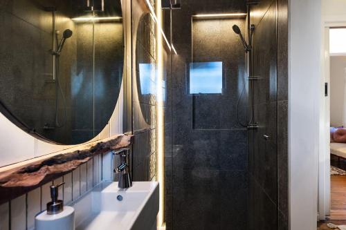 a bathroom with a sink and a shower with a mirror at Cabrito in Daylesford