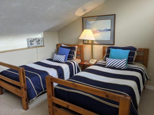 a room with two beds with blue and white stripes at Tamarron Lodge Loft 510 in Durango