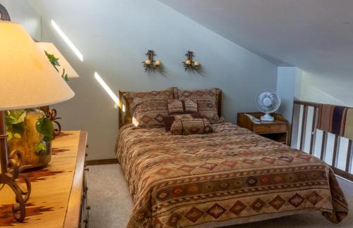 a bedroom with a bed and a table with a lamp at Tamarron Lodge Loft 511 in Durango