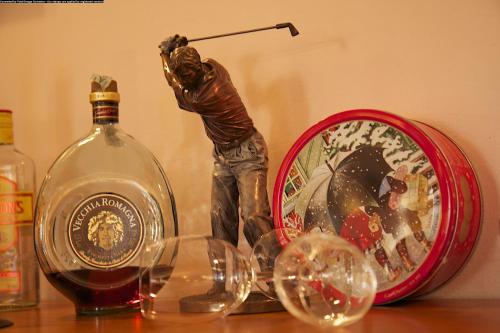 a statue of a man playing golf next to a bottle of wine at Centrale in Courmayeur