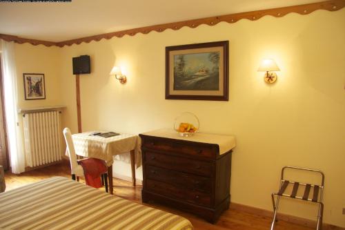 a bedroom with a dresser and a bed and a table at Centrale in Courmayeur