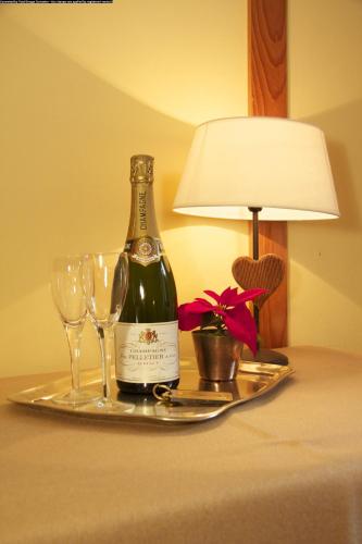 a bottle of wine on a tray with glasses and a lamp at Centrale in Courmayeur