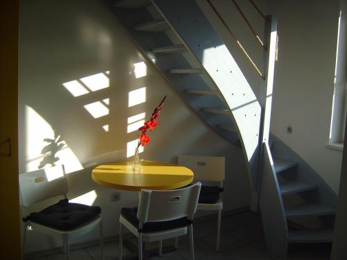 un tavolo giallo e sedie in una stanza con scale di Penzion ALEXSPORT a Třeboň
