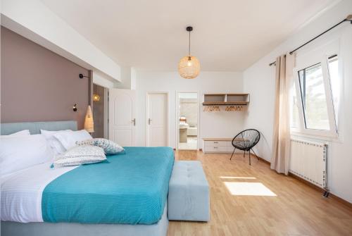 a bedroom with a blue bed and a chair at Villa VerdeBlu Rethymno Crete in Rethymno Town