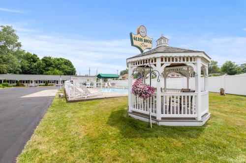 a white gazebo in the grass next to a pool at Glass House Inn Erie Near I-90 & I-79 in Erie