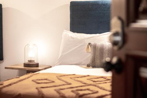 a bedroom with a bed with a pillow and a lamp at Mestizo Antigua in Antigua Guatemala