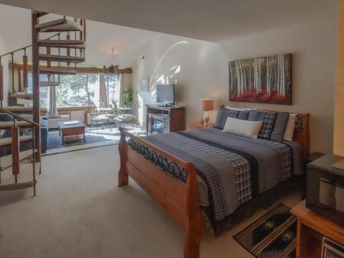 a bedroom with a bed and a staircase and a living room at Tamarron Lodge Loft 314 in Durango