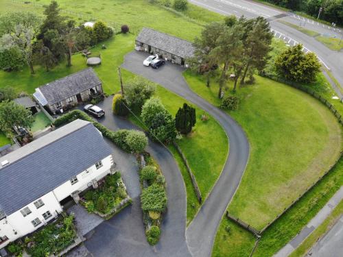 an aerial view of a house with a winding road at Lune Cottage nestled between Lake District and Yorkshire Dales in Tebay