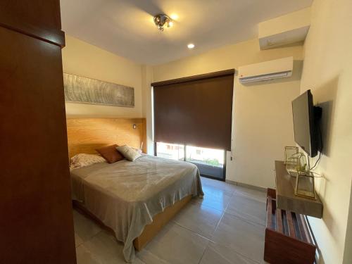 a bedroom with a bed and a large window at condesa 12 sublime depa a 100 pasos de la playa in Mazatlán