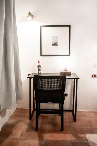 a table with a chair and a picture on the wall at Mestizo Antigua in Antigua Guatemala